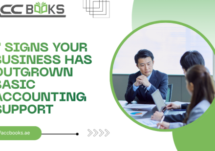 A stressed business owner sitting at a cluttered desk overflowing with paper invoices, receipts, and spreadsheets, while a small, outdated calculator sits broken in the foreground. Behind them, a large wall chart shows a steep upward growth curve, signaling that the current basic bookkeeping system is failing. The image visually represents the 7 Signs Your Business has outgrown its current financial support structure.